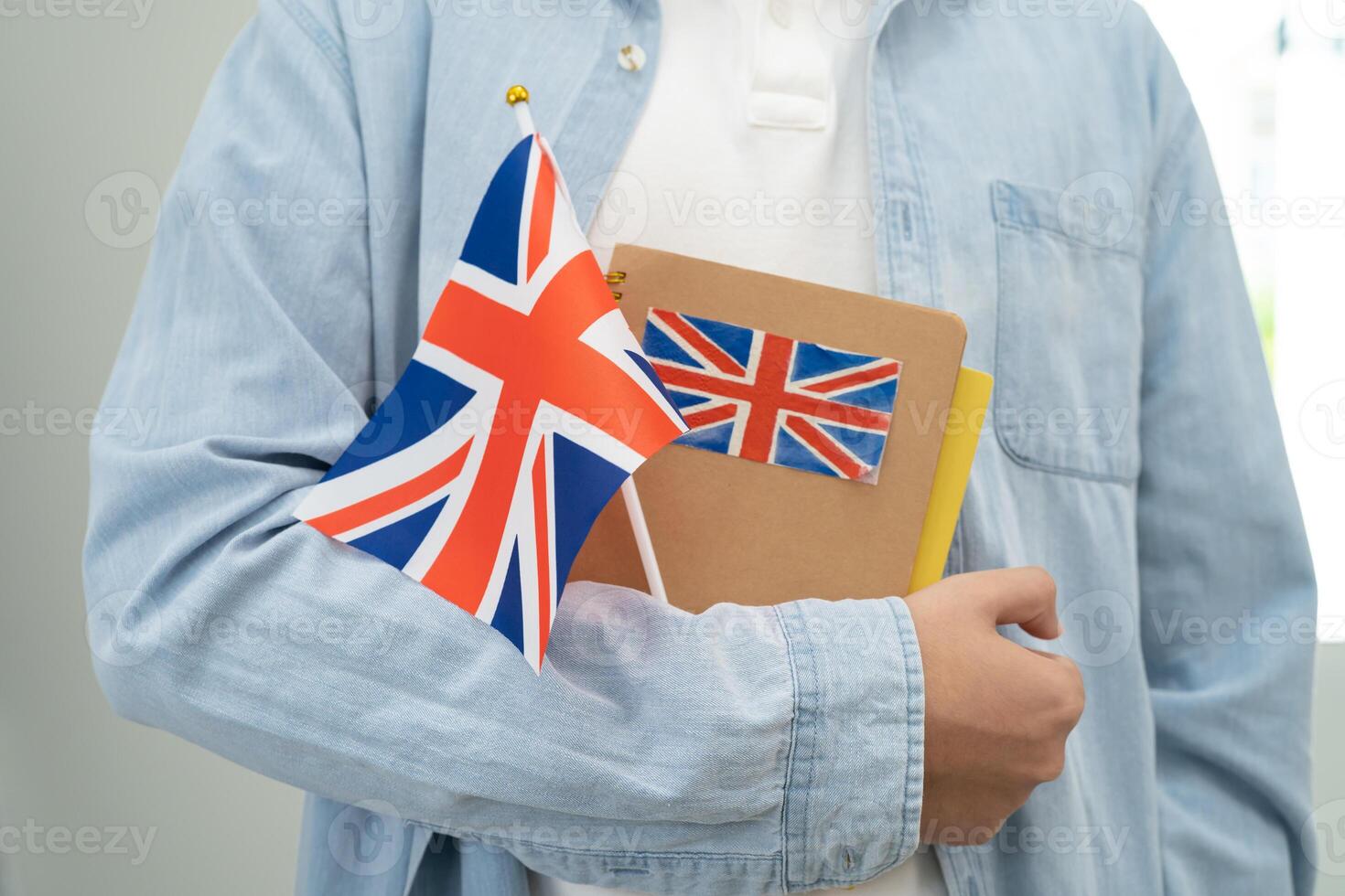 Learn English language, Asian teenage student hold book with flag in course at school. photo