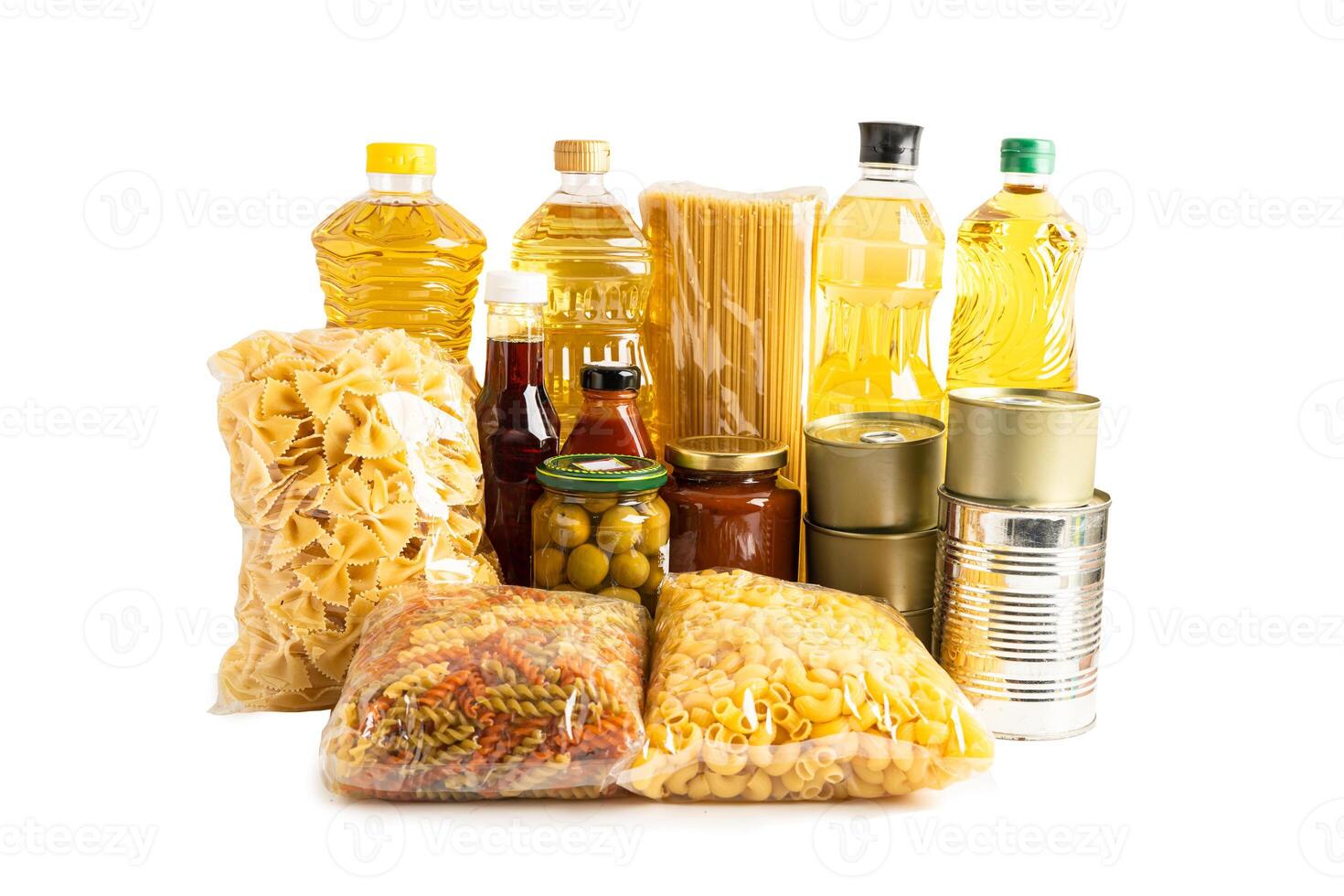 Foodstuff for donation isolated on white background with clipping path, storage and delivery. Various food, pasta, cooking oil and canned food in cardboard box. photo