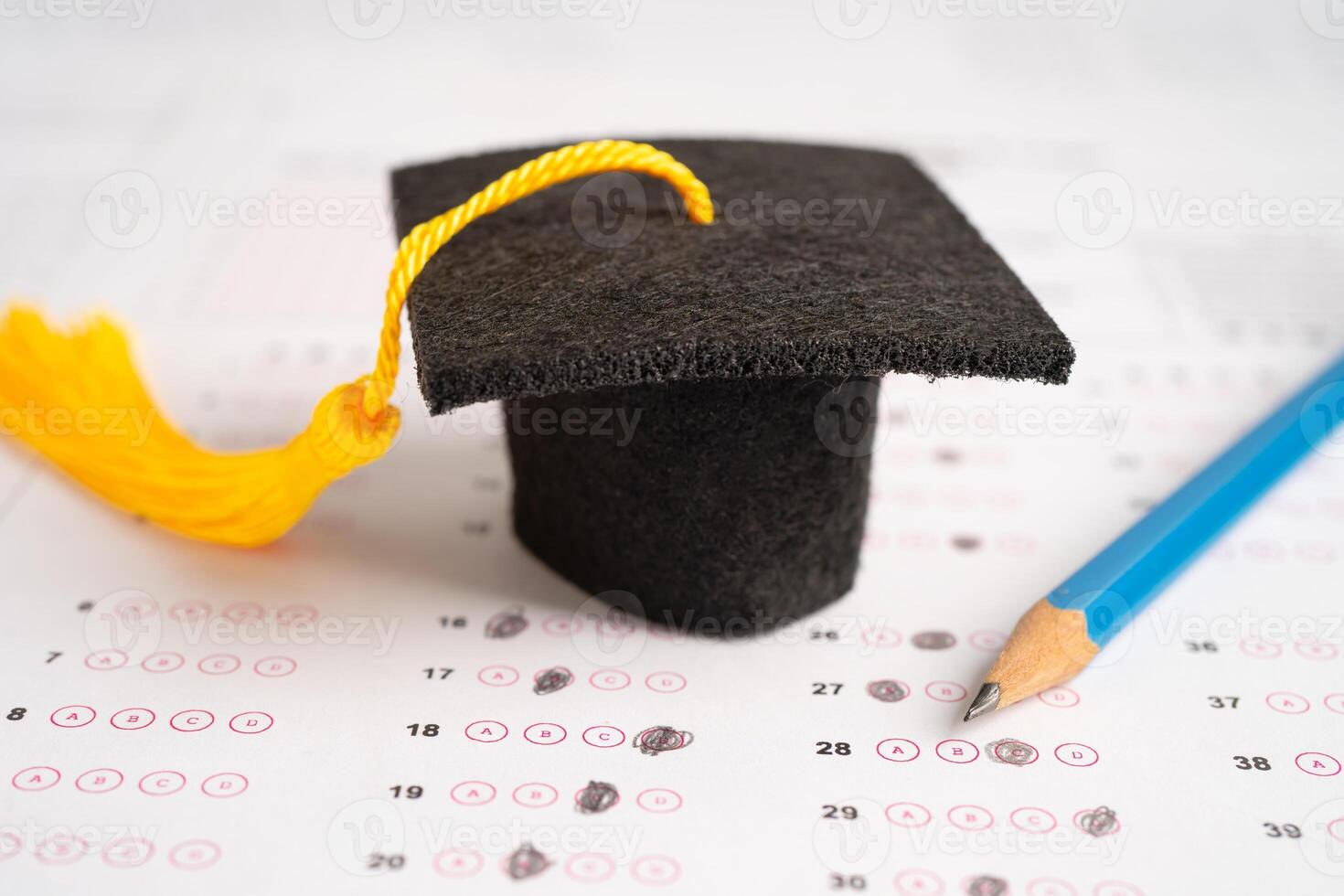 Graduation gap hat and pencil on answer sheet background, Education study testing learning teach concept. photo