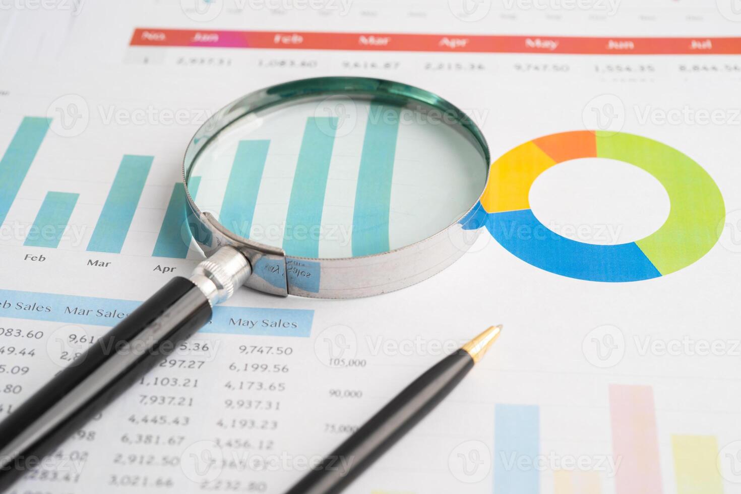 Magnifying glass on spreadsheet and graph paper. Financial development, Banking Account, Statistic, Investment Analytic research data economy, Business. photo