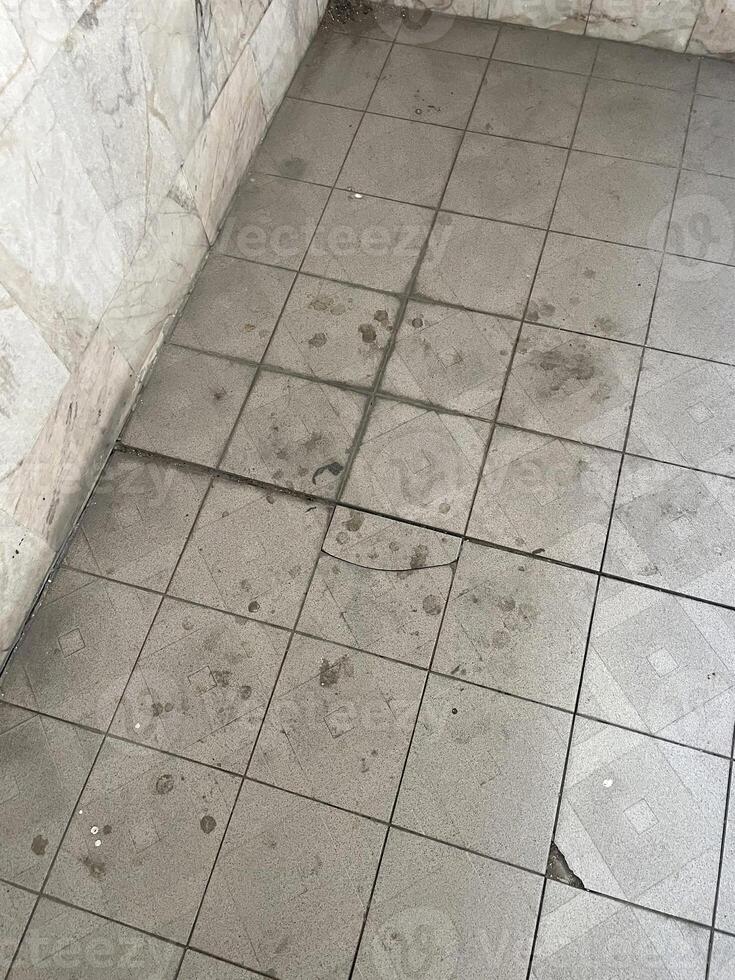 dirty floor with gray tiles photo