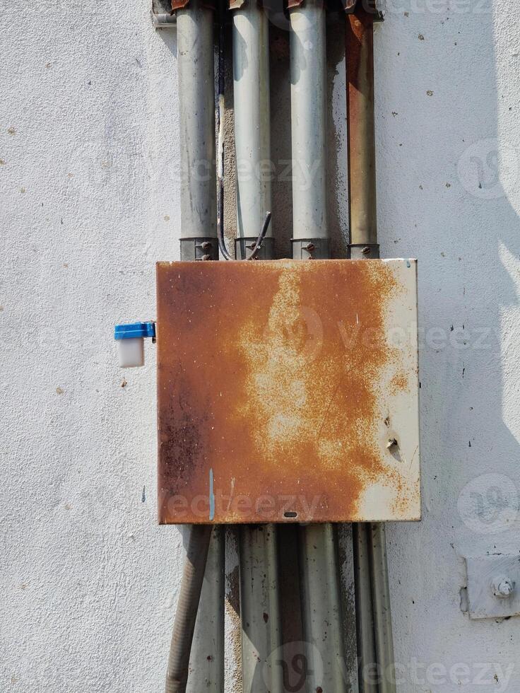 rusty electric box and metal pipe on a white background photo
