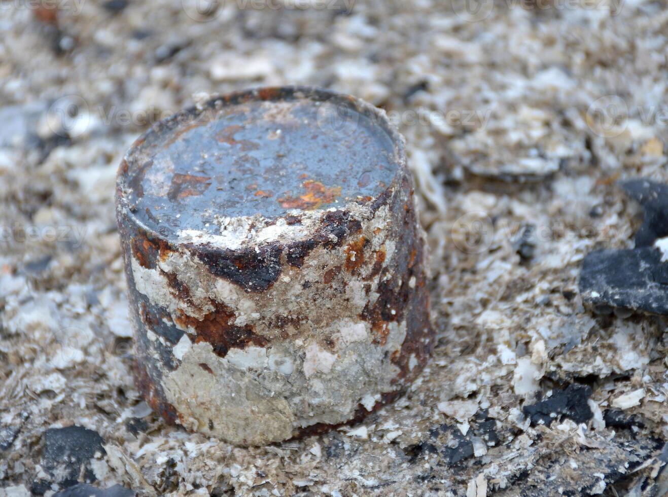 close up rusty can on dirty ash photo
