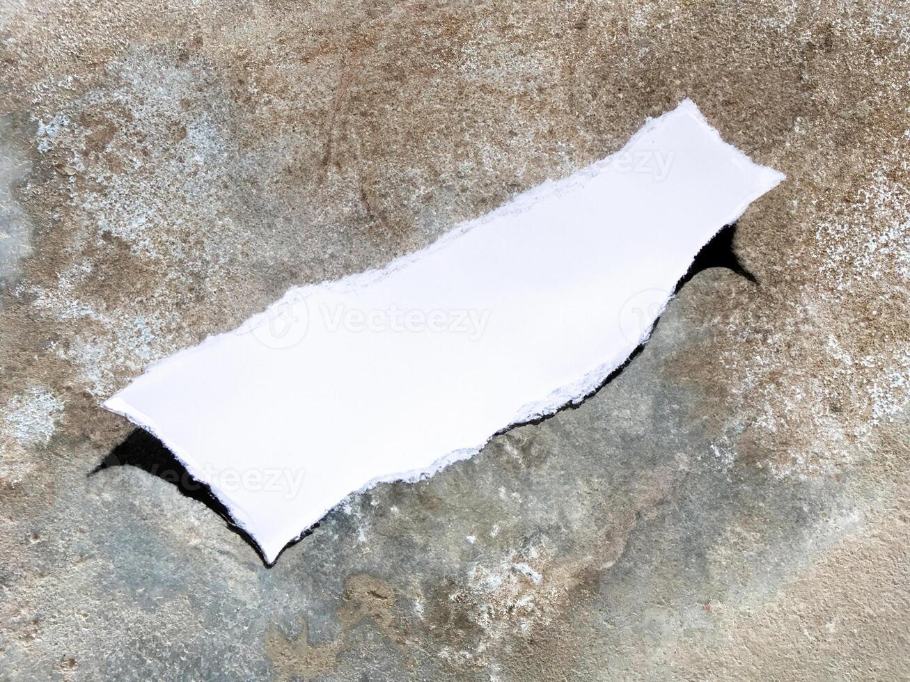 ripped torn paper on stone texture background. photo