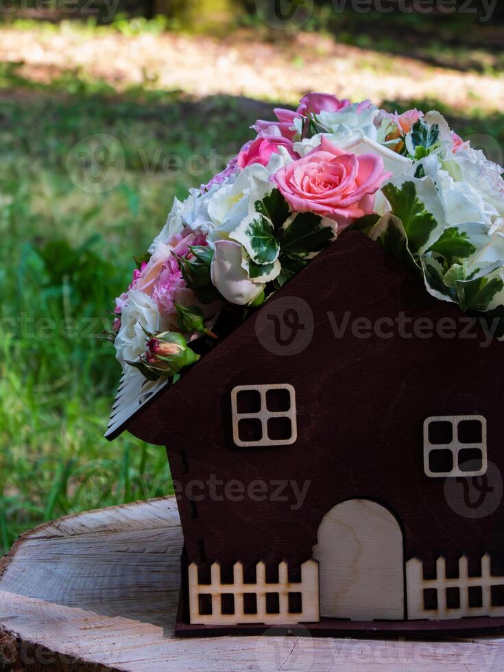 pot in the shape of a house with flowers, landscaping concept photo