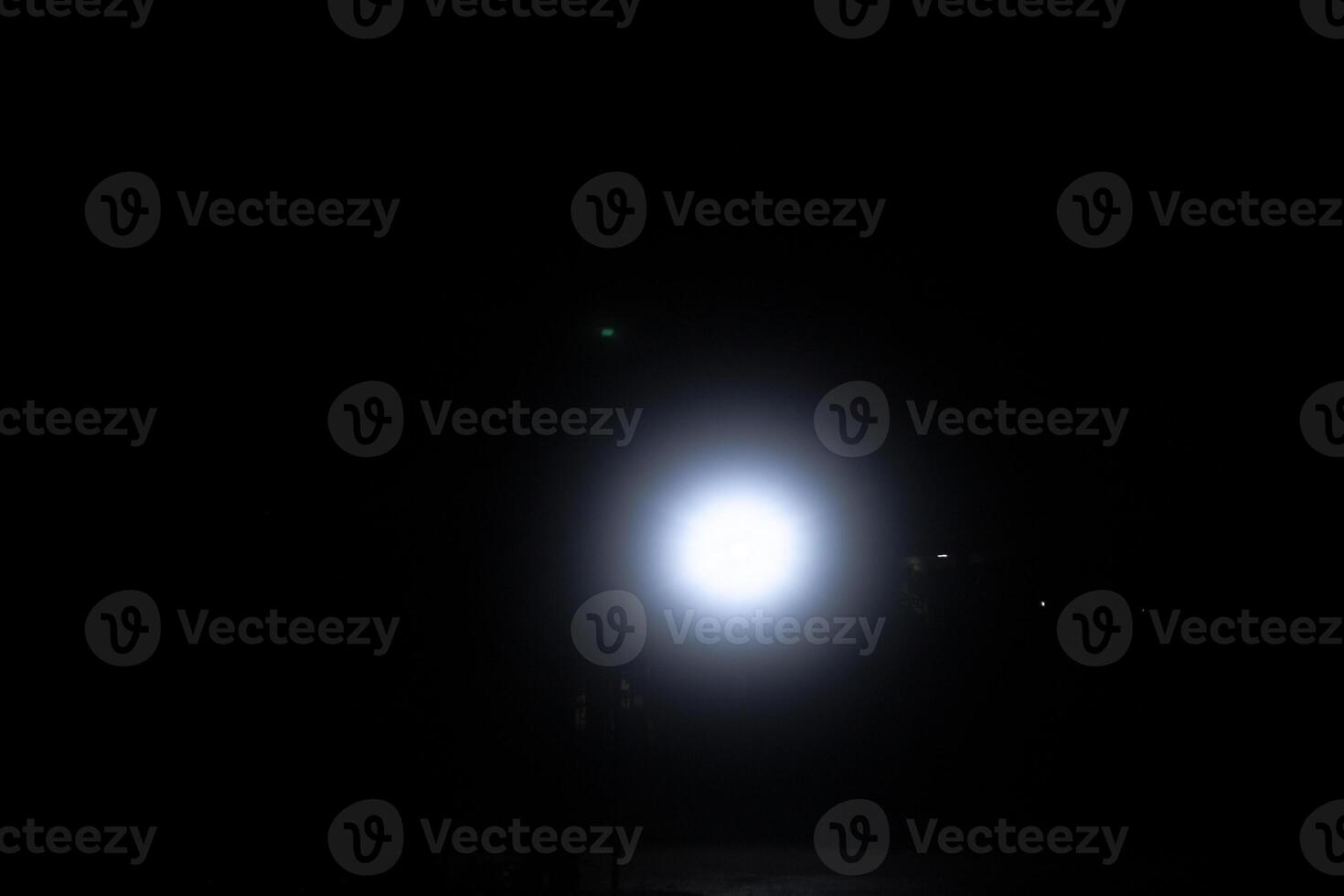 spot light bulb shin in middle of the dark black background with Silhouette House residential area photo