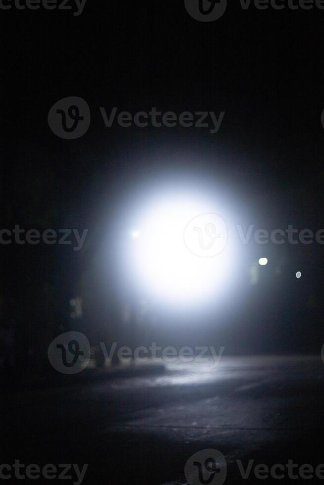 spot light bulb shin in middle of the dark black background with Silhouette House residential area photo