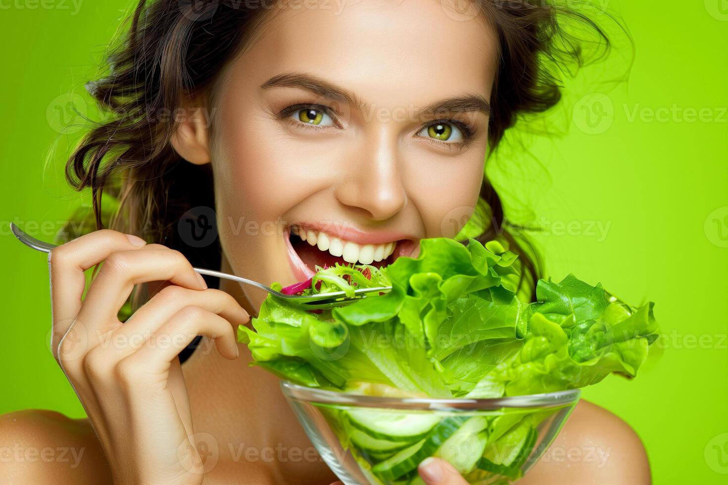 Caucasian woman holding a salad on a green background, healthy living concept photo