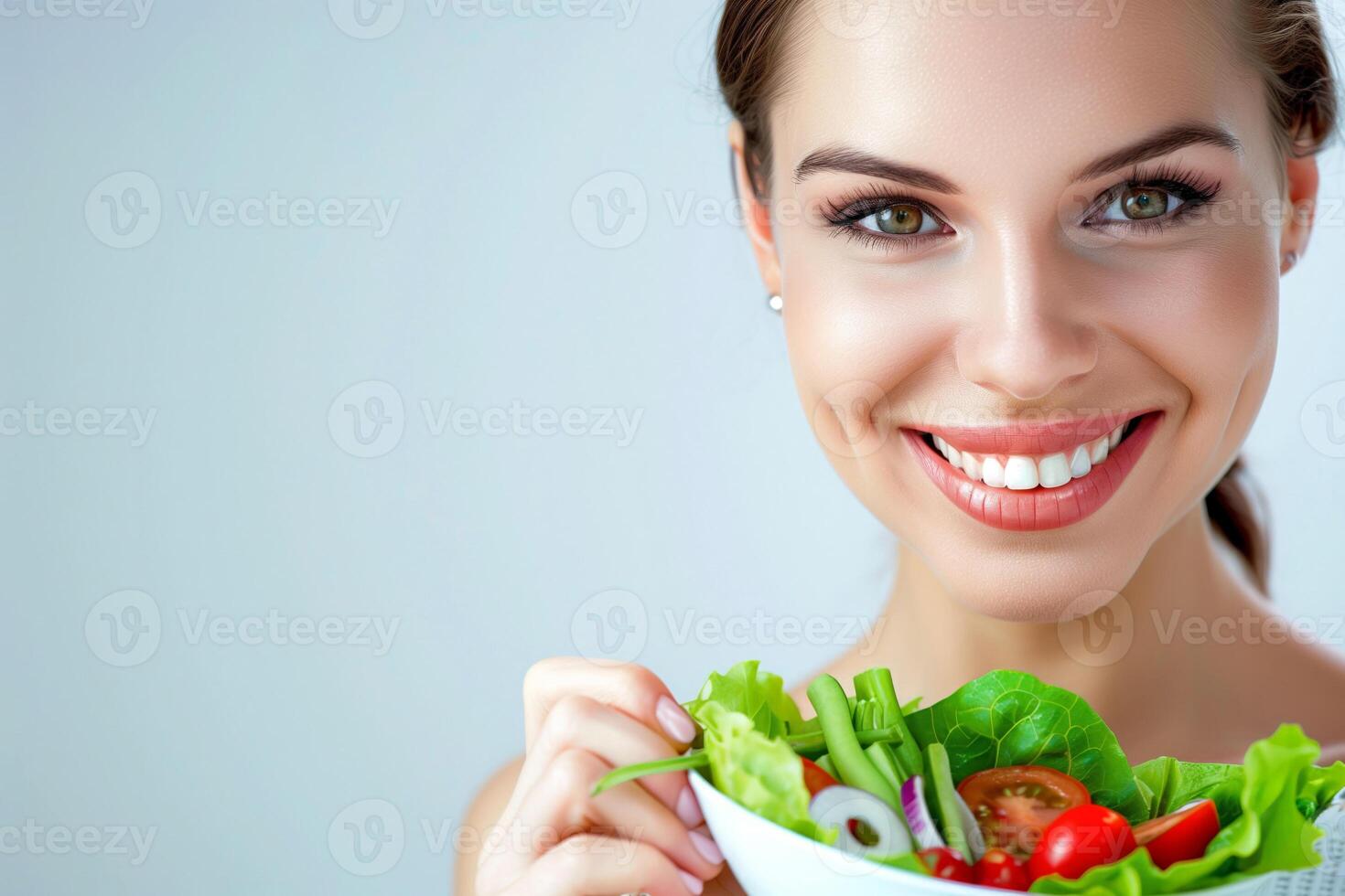 Smiling woman eating a nutritious salad on a white background, copy space photo