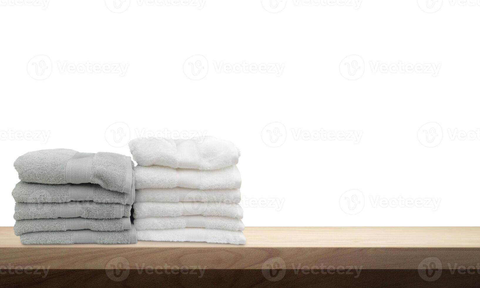 A pile of towels, neatly folded and placed on a wooden table. photo