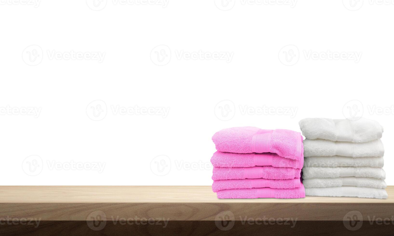 A pile of towels, neatly folded and placed on a wooden table. photo