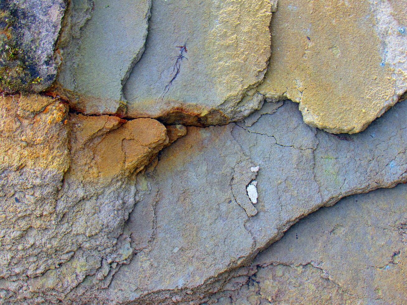 a close up of a rock wall with cracks photo