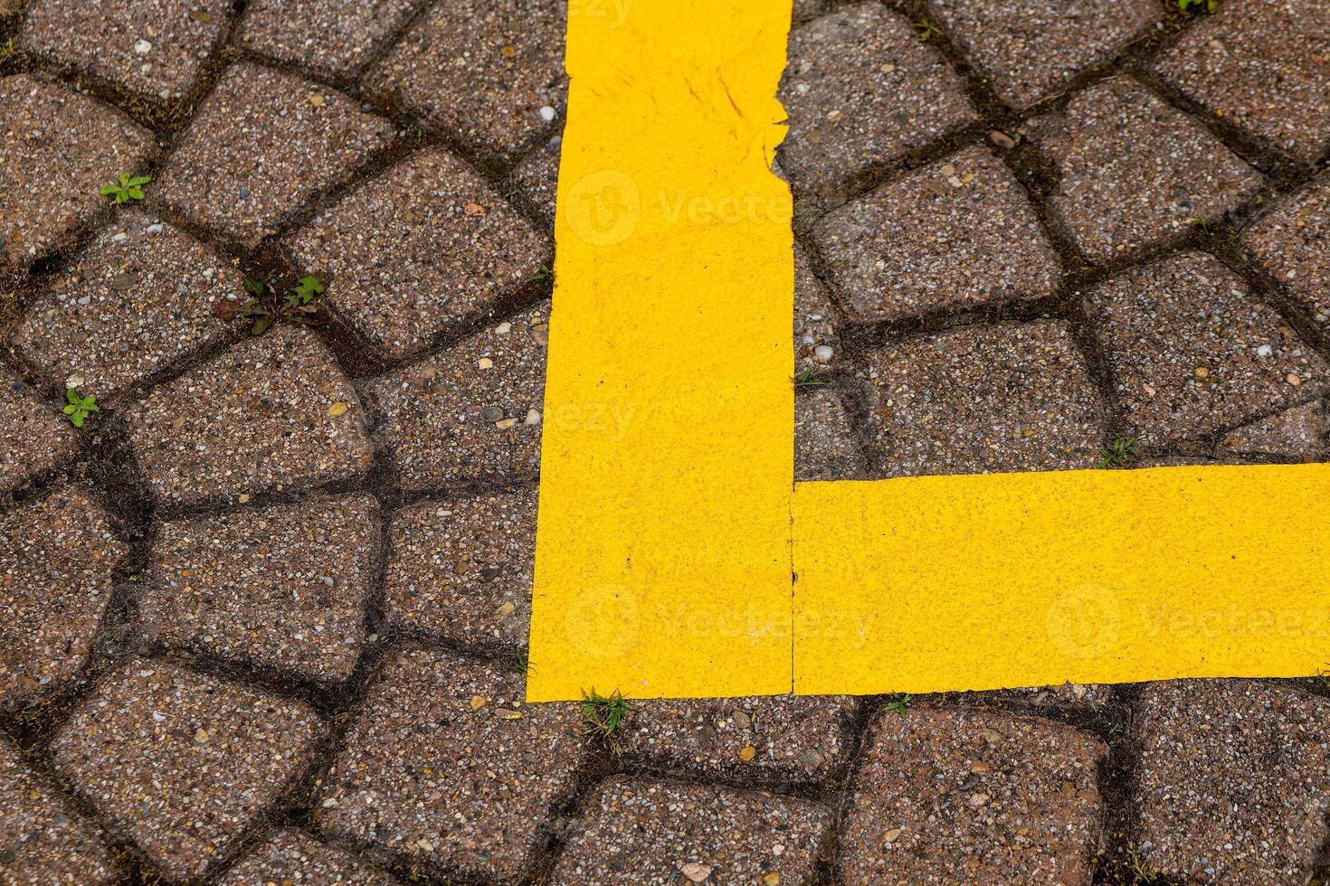yellow line is drawn on a brick walkway photo