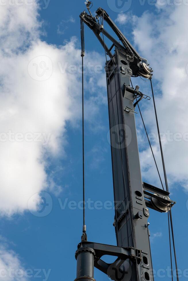 crane is suspended in the air with a blue sky in the background photo