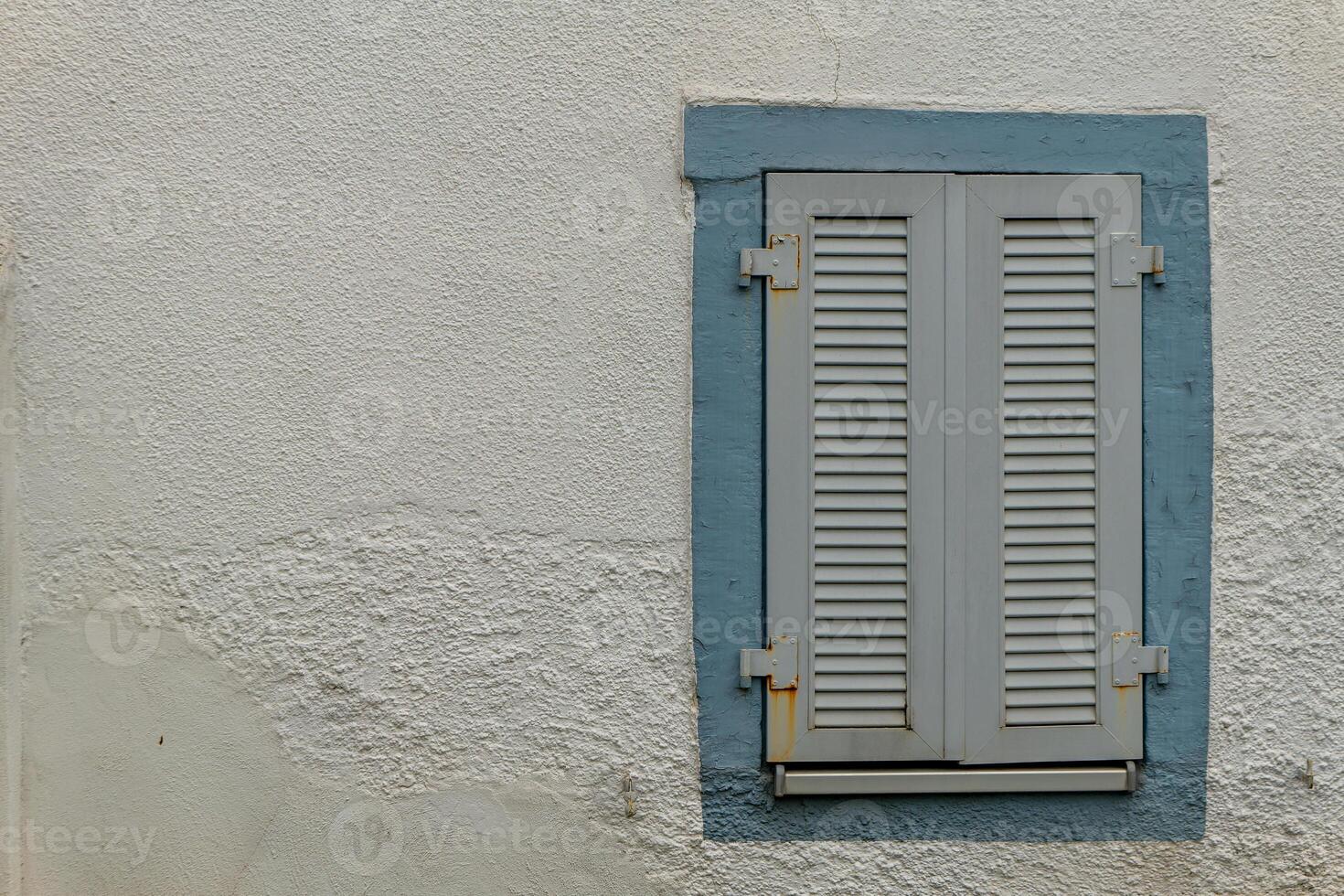 window with shutters is shown against a wall photo