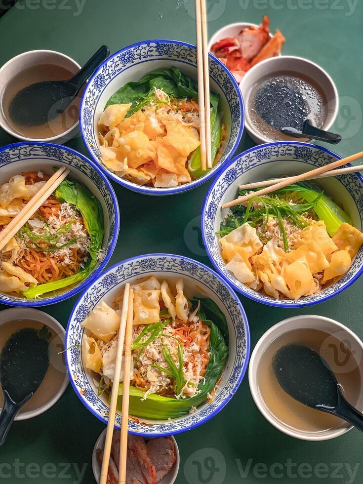 Noodle soup with wonton dumplings and vegetables. separate sauce. Top view photo