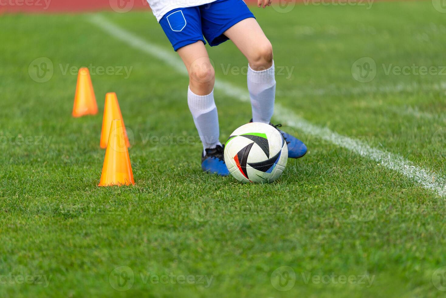 Soccer player in training going around cones on the field close up. Great for children in sports, healthy life, growing up, success, and hard work photo