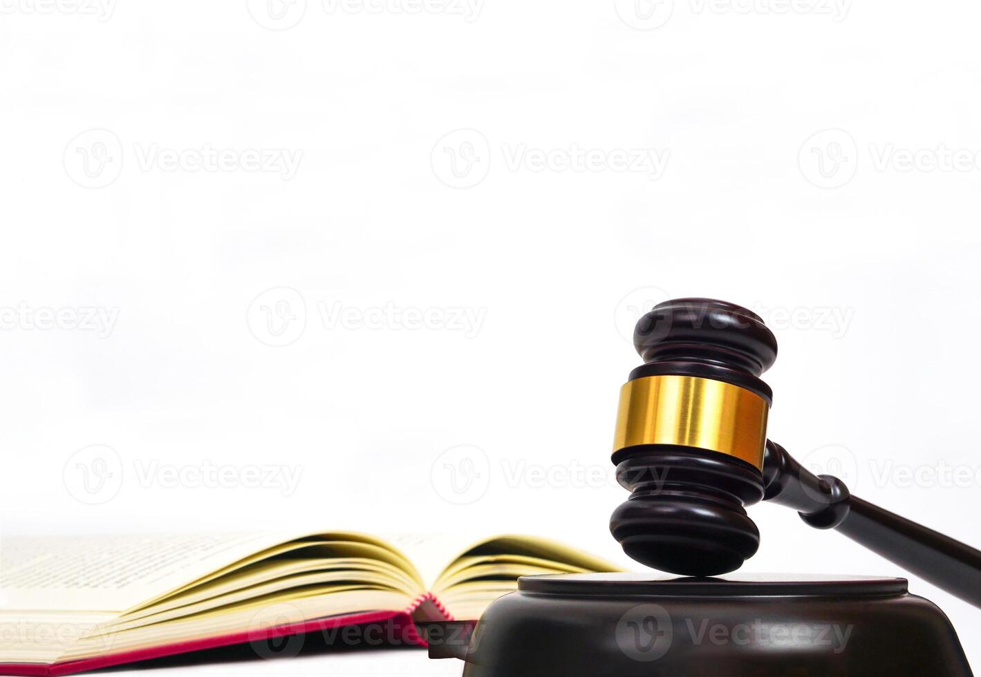 Close up of judge gavel on law book in white background. Lawyer, law, justice system, hammer auction. photo