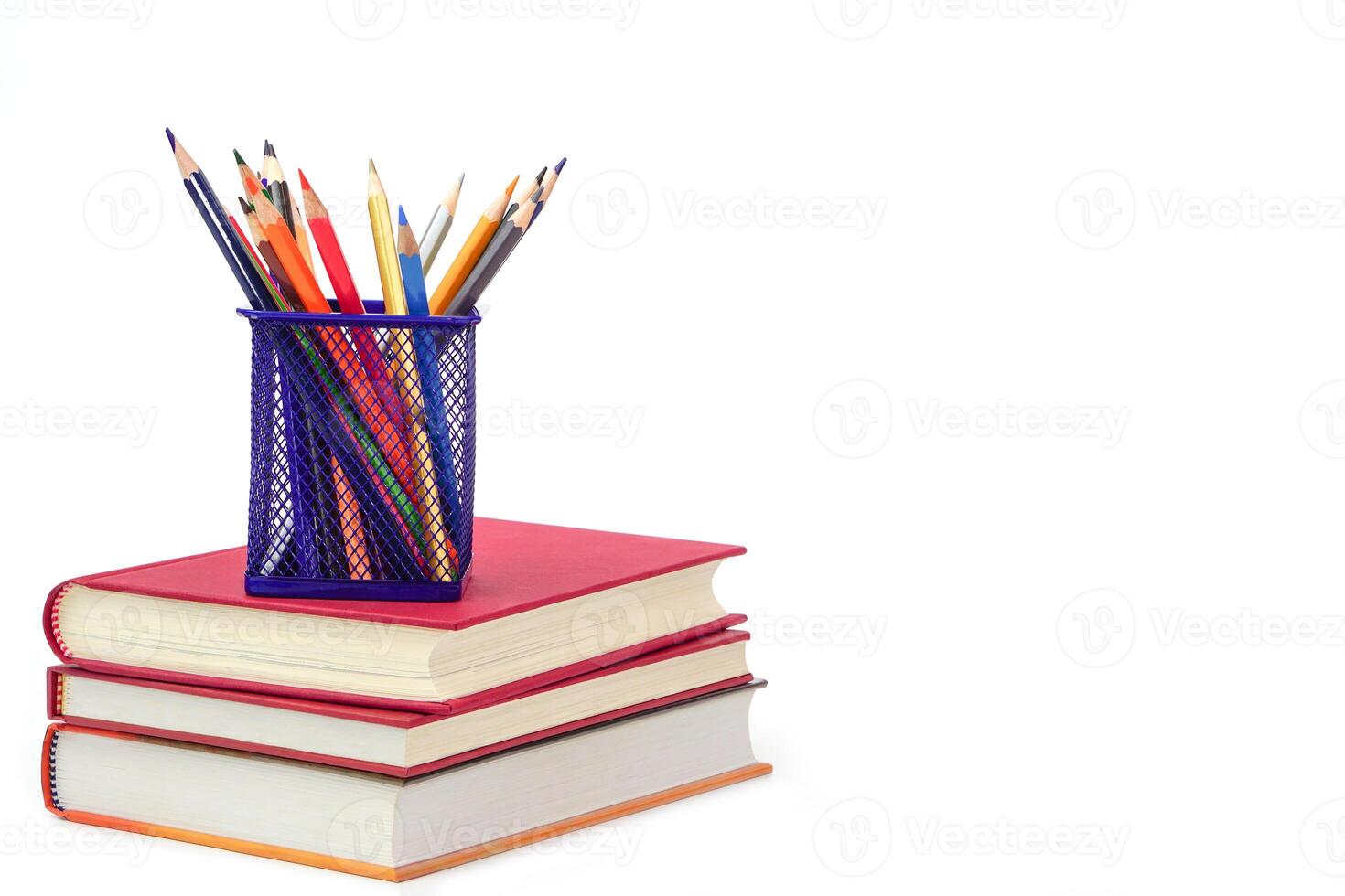 Crayon or colored pencils in box laying on a stack of books, white background. Knowledge and education concept. photo