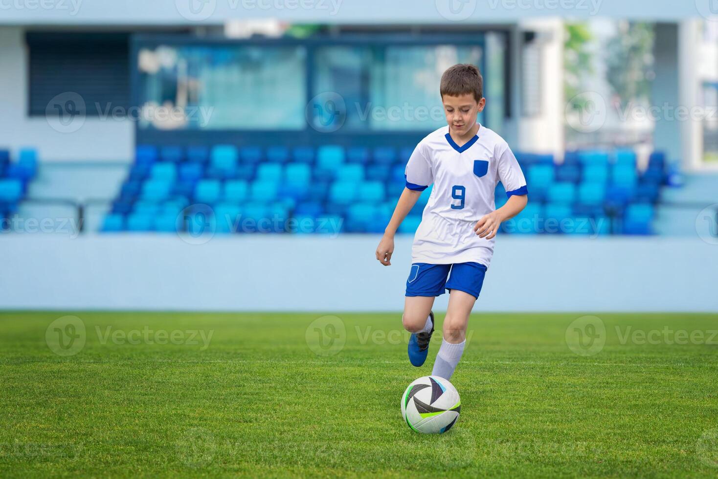 Young soccer player in a white dress dribbling the ball on a soccer match, showcasing agility and skill photo