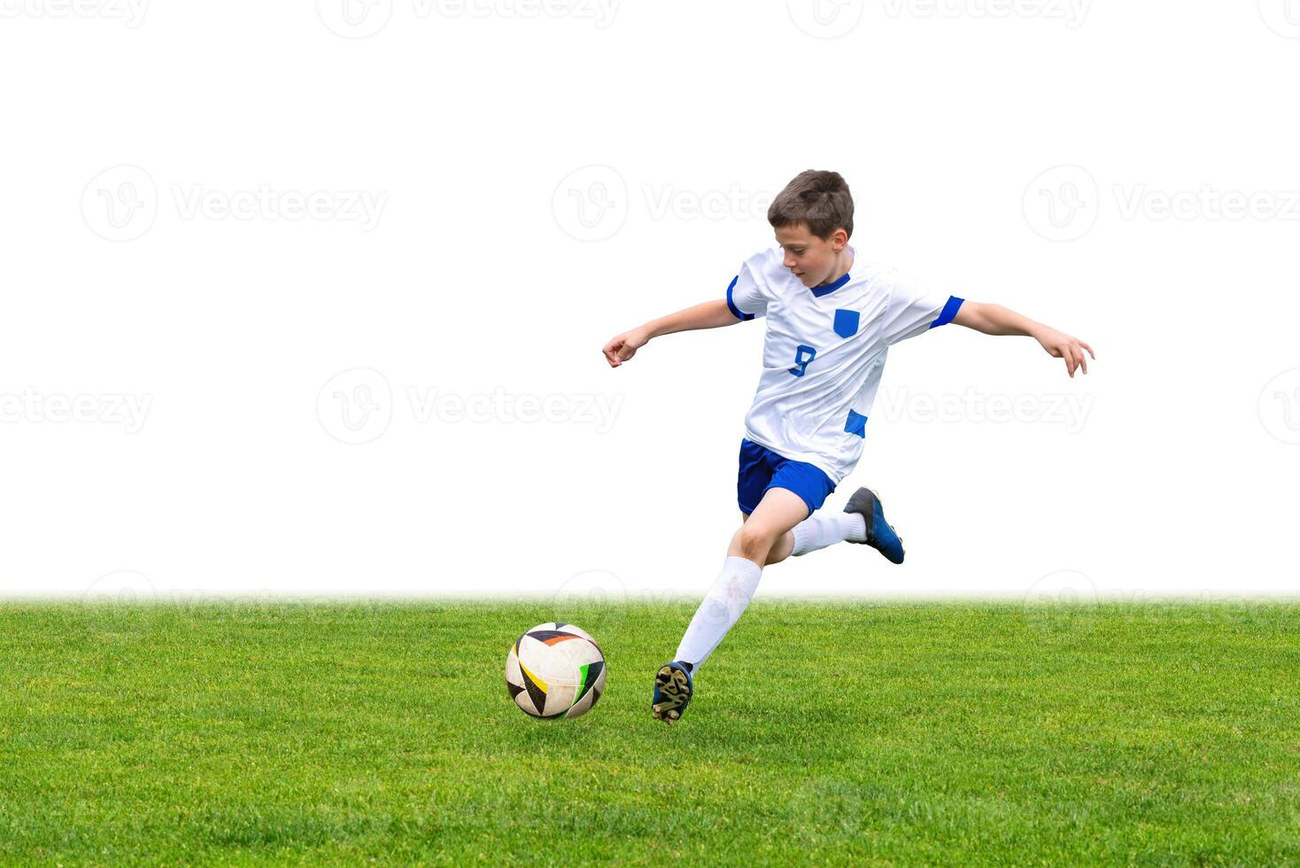 Young boy kicks a soccer ball on a grassy field, with a clean white background for easy text overlay. This versatile stock image is perfect for sports, fitness, or youth-focused content photo