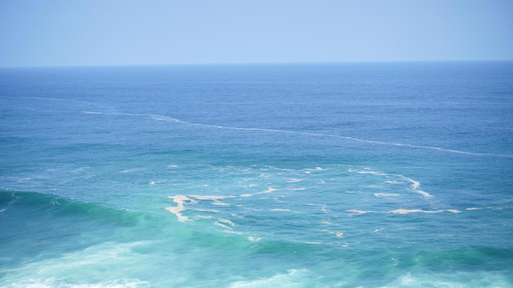 Front view over the ocean and white foam waves. Feel calm, cool, relaxed. Idea for cool background and copy space above. photo