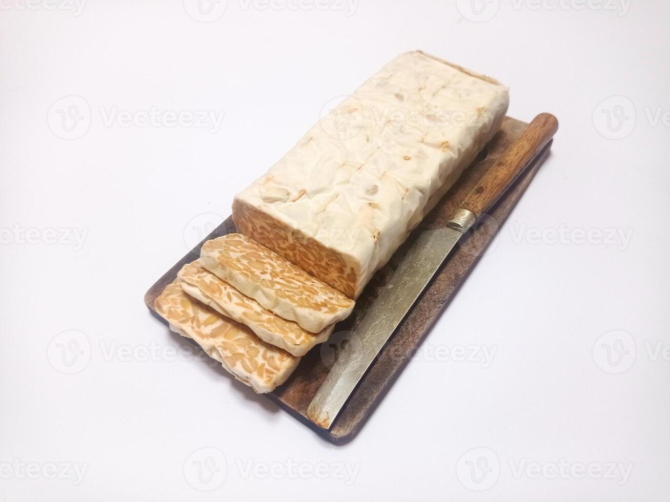 Close-up of tempeh food, tempeh pieces and knife on wooden cutting board photo