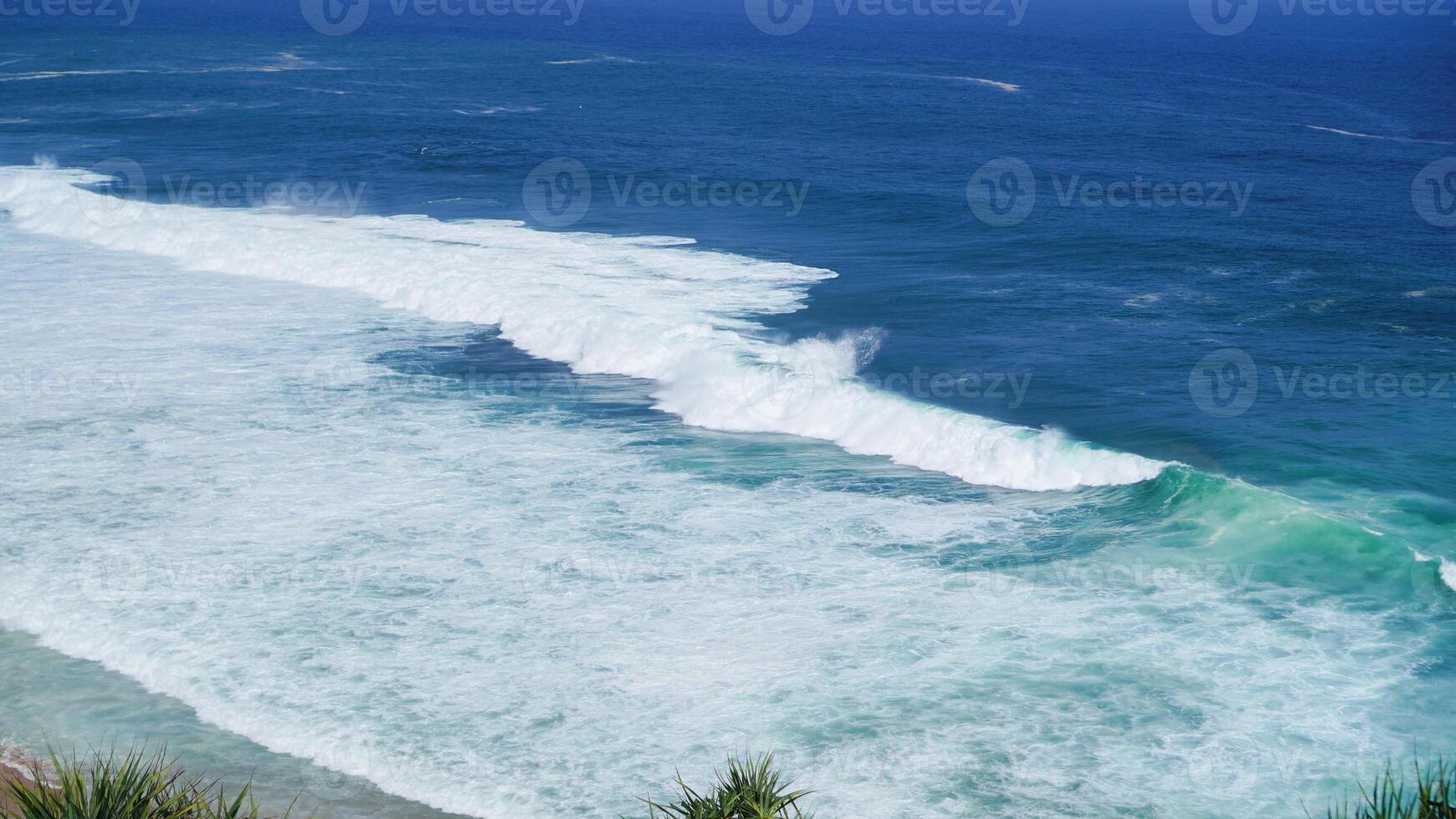 view of rolling waves and ocean from the top front view and surrounded by green plants. The beach is very beautiful. Idea as background, holiday, poster photo