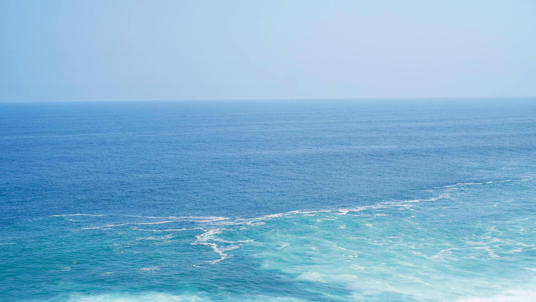 Front view over the ocean and white foam waves. Feel calm, cool, relaxed. Idea for cool background and copy space above. photo