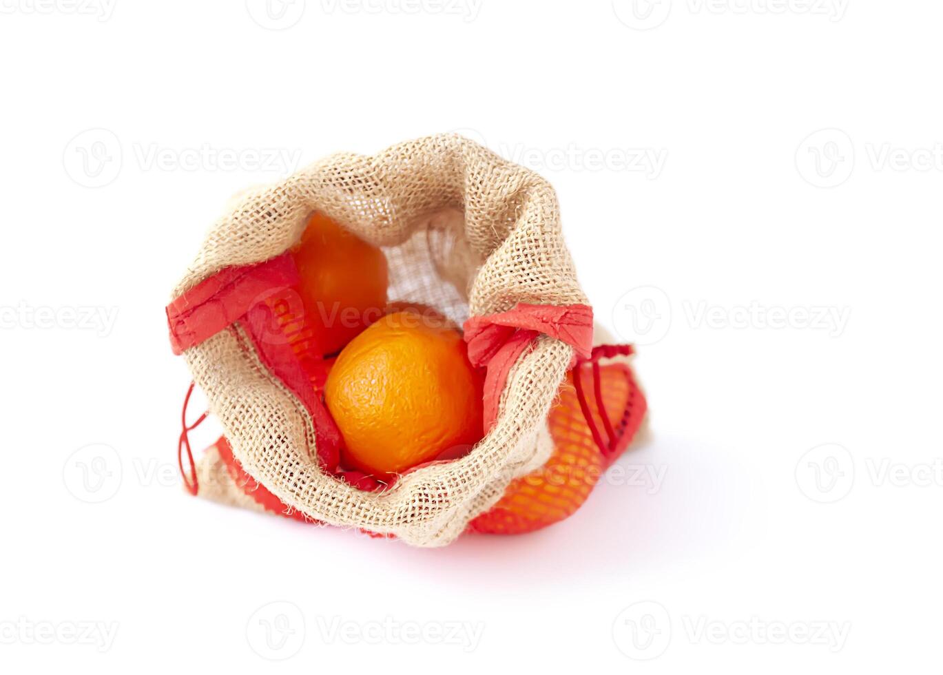 Fresh orange fruits in a burlap bag on white background photo