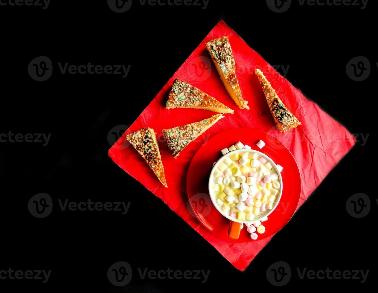 Cocoa drink with colorful small marshmallows on red background photo