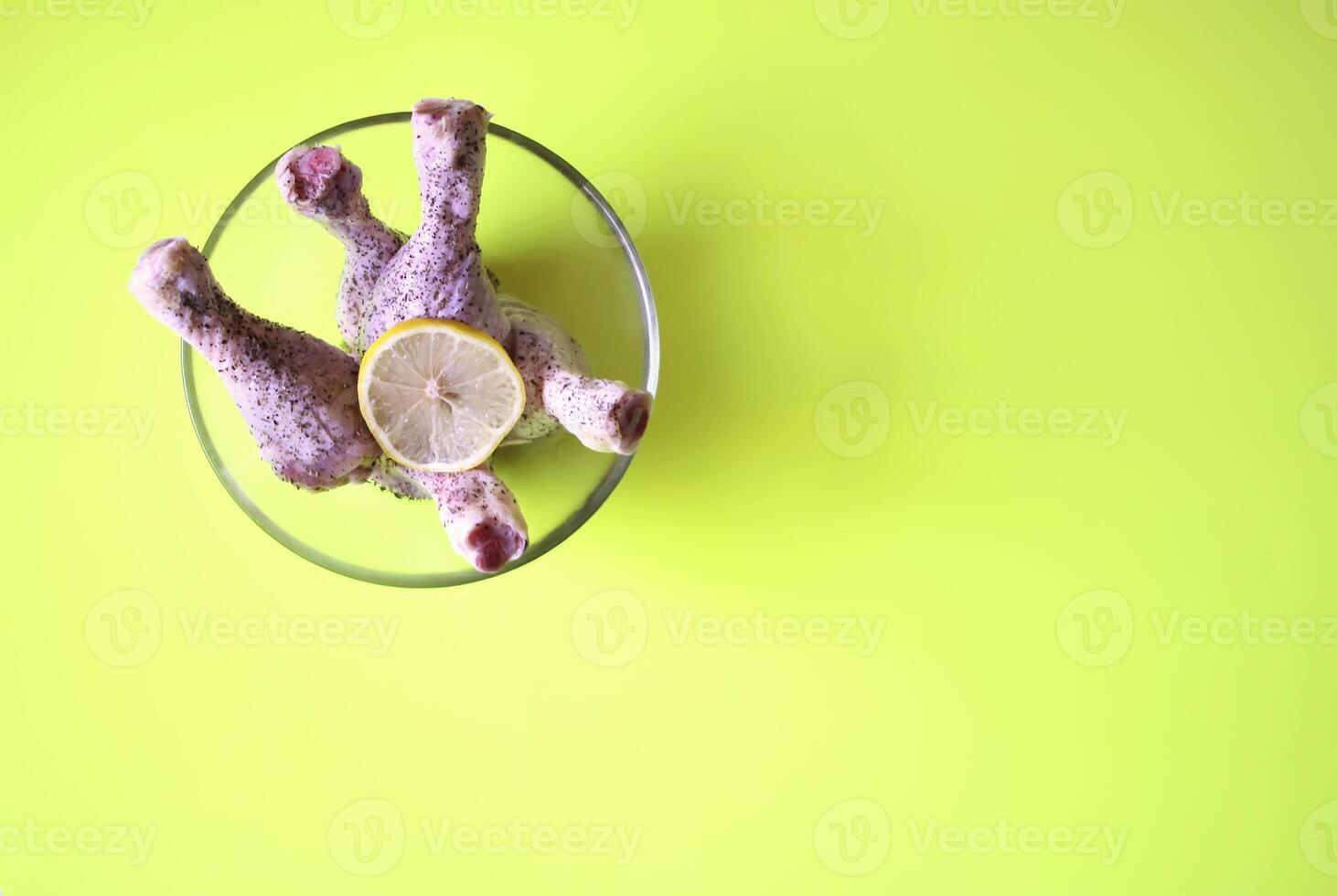 Raw chicken legs with herbs and lemon slice prepared for cooking. photo