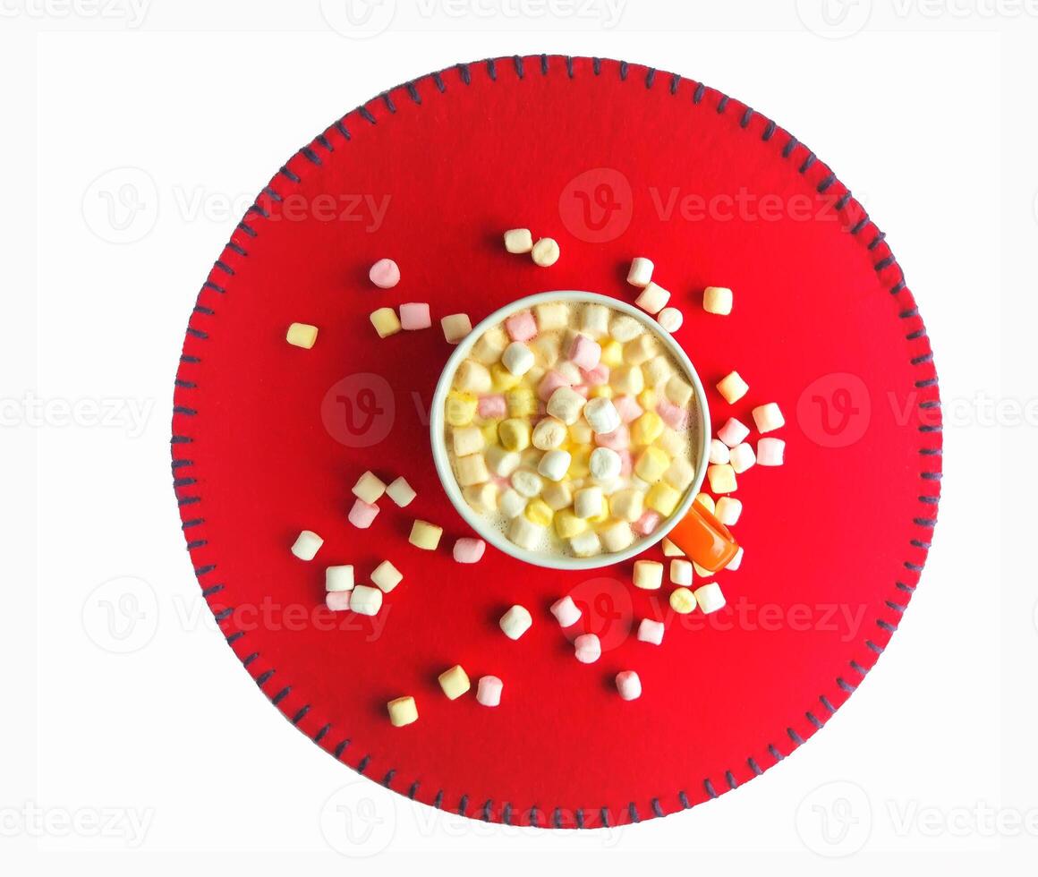 Cocoa drink with colorful small marshmallows on red background photo