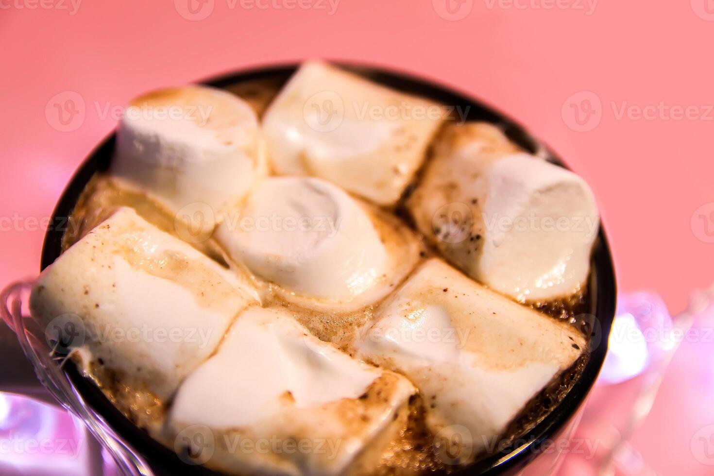 Ceramic mug with hot fresh cocoa drink with marshmallow on soft pink background. photo