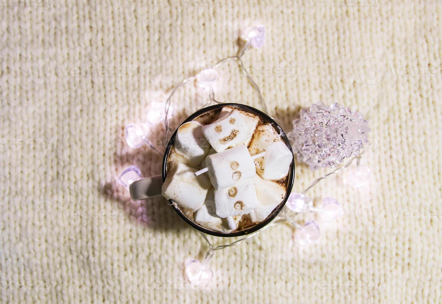 Ceramic mug with hot fresh cocoa drink and melted handmade marshmallow snowman. photo