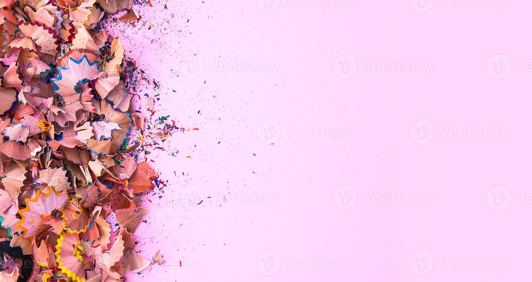 Wooden pencil shavings and colorful crumbs of graphite from sharpener. Top view. photo