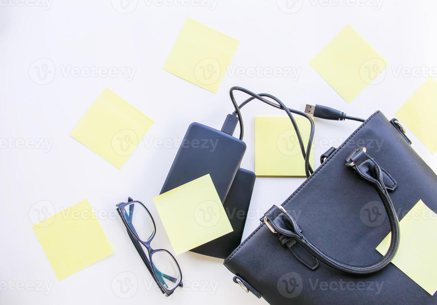 Composition with black bag, hard disks, colorful paper empty stickers and glasses. photo