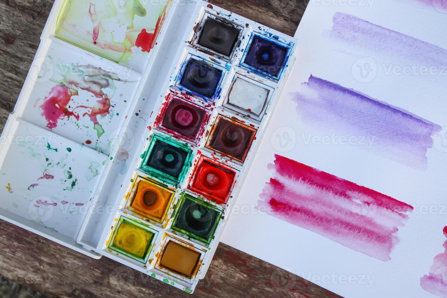 Watercolor paints, palette and paper photo