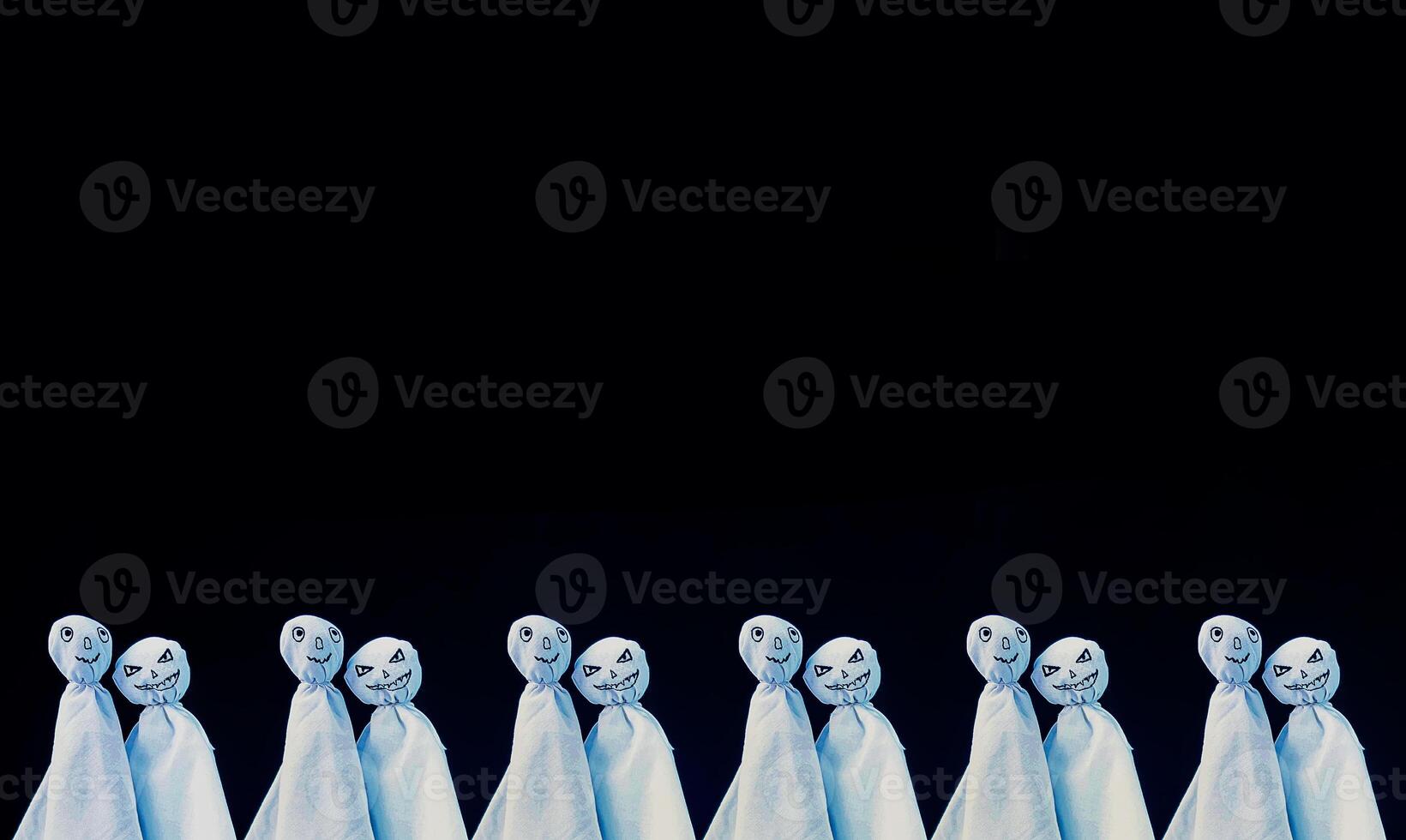 Decoration for Halloween. Two ghost figures on black background. Handmade decor for party. photo