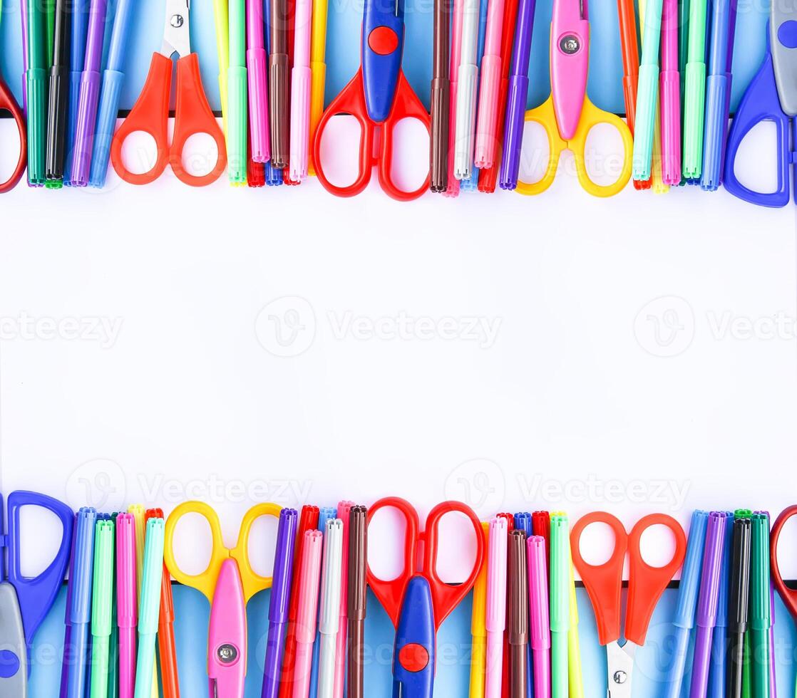 School supplies. Back to School design elements. Colorful markers and scissors on white paper background. Symmetrical design. photo