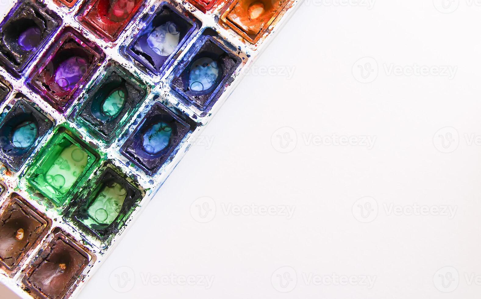 Watercolor paints, brushes and paper on white background. Flat lay, top view photo