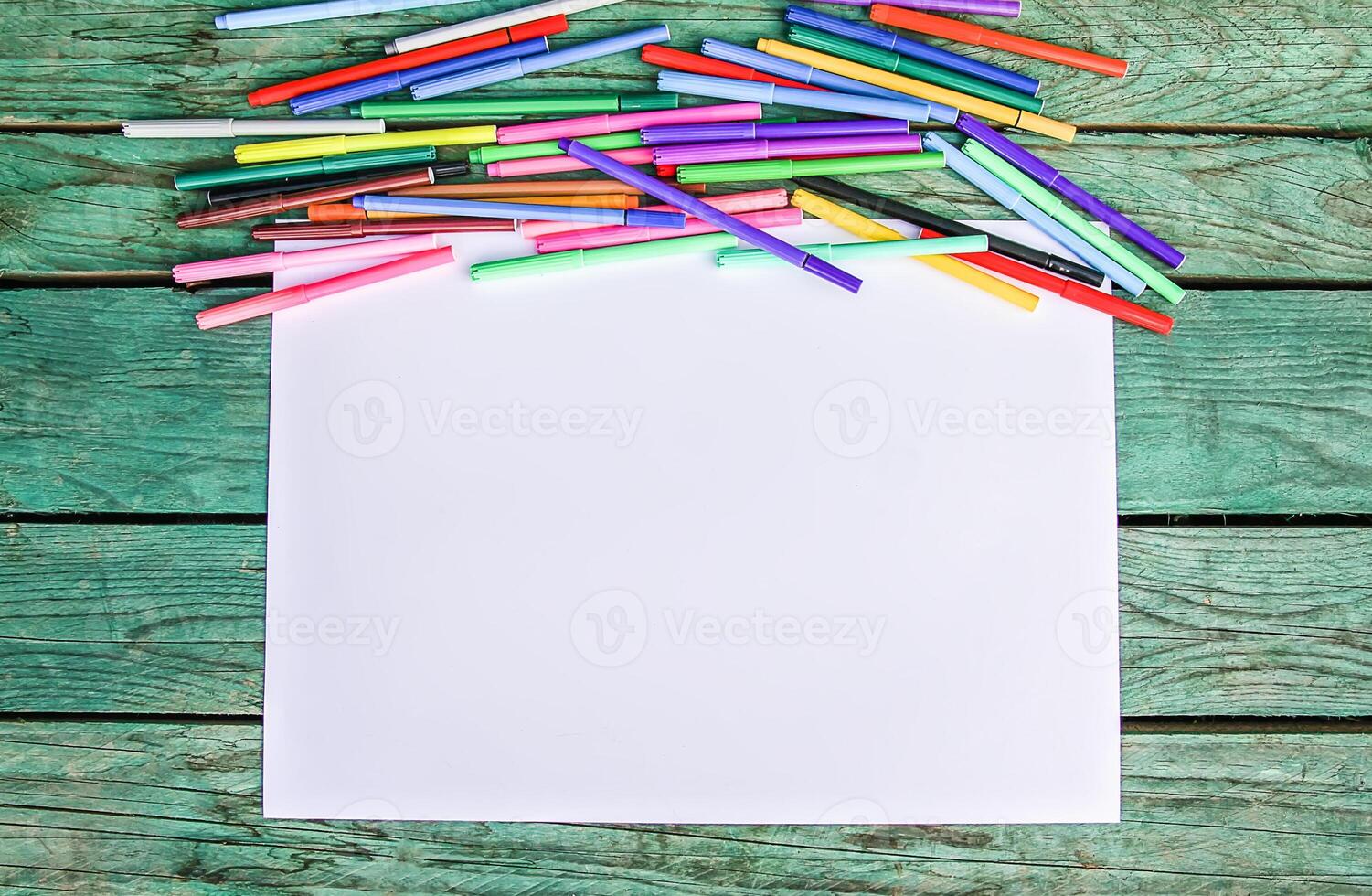 School supplies. Back to School design elements. Colorful markers and white empty paper sheet. photo
