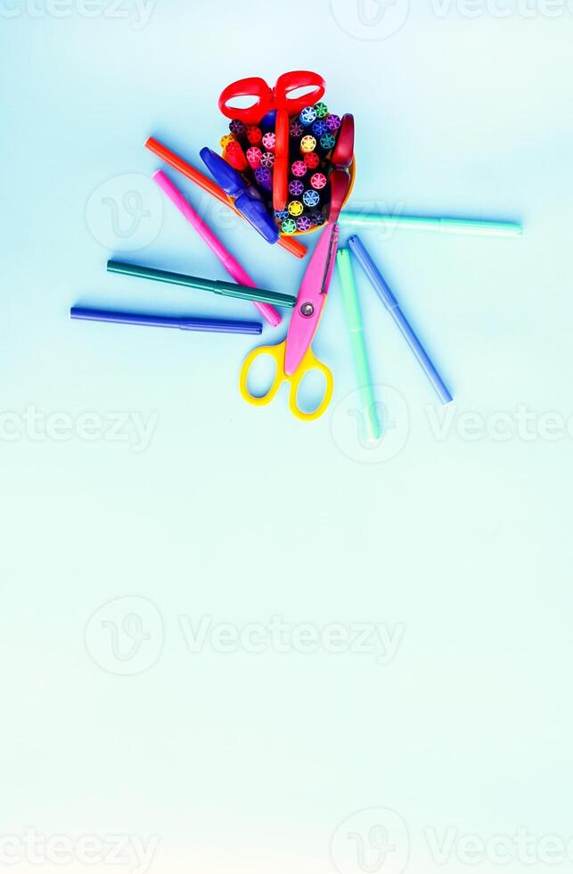School supplies. Back to School design elements. Colorful markers and scissors on light blue background. photo