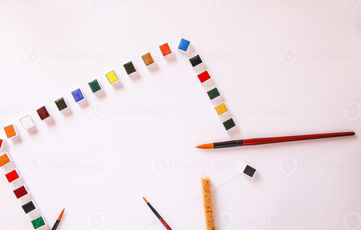 Watercolor paints, brushes and paper on white background. Flat lay, top view photo
