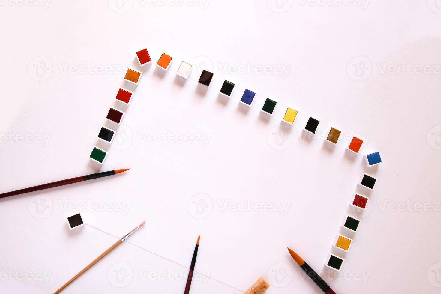 Watercolor paints, brushes and paper on white background. Flat lay, top view photo