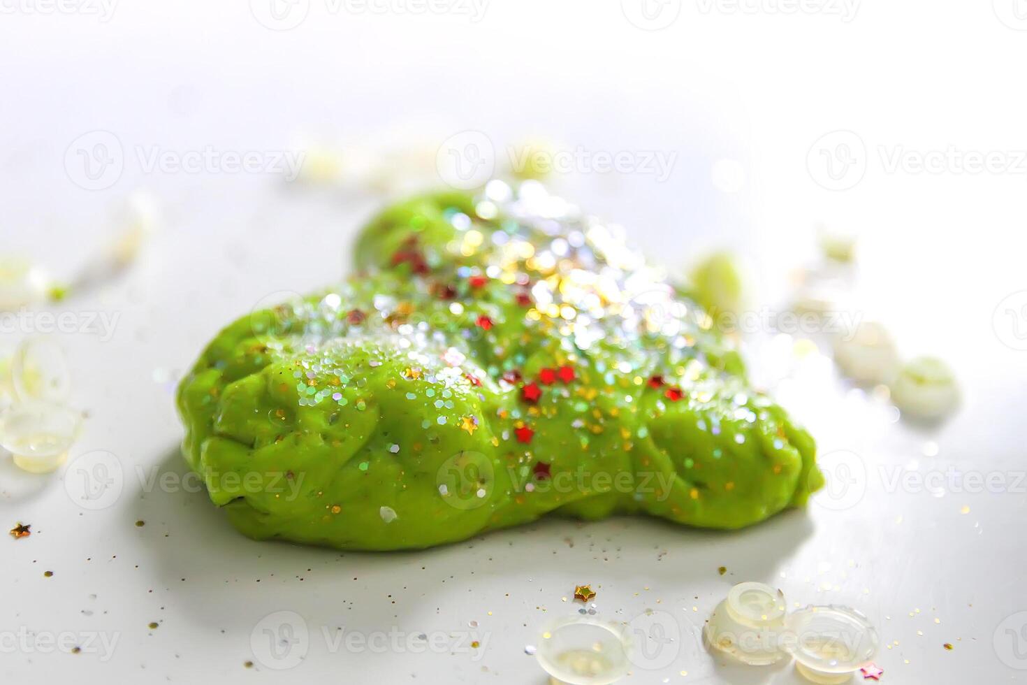 Green heart with shiny glitters made from slime photo