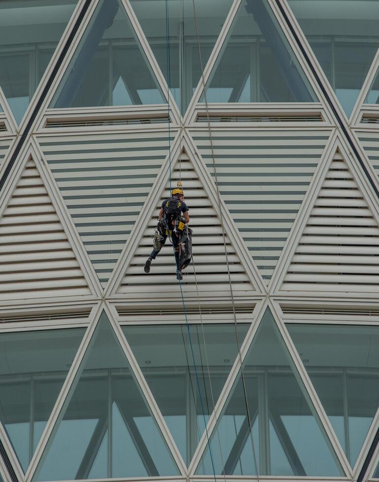 Italy 2024 A rope operator with a harness, lowering himself onto the facade of a building photo