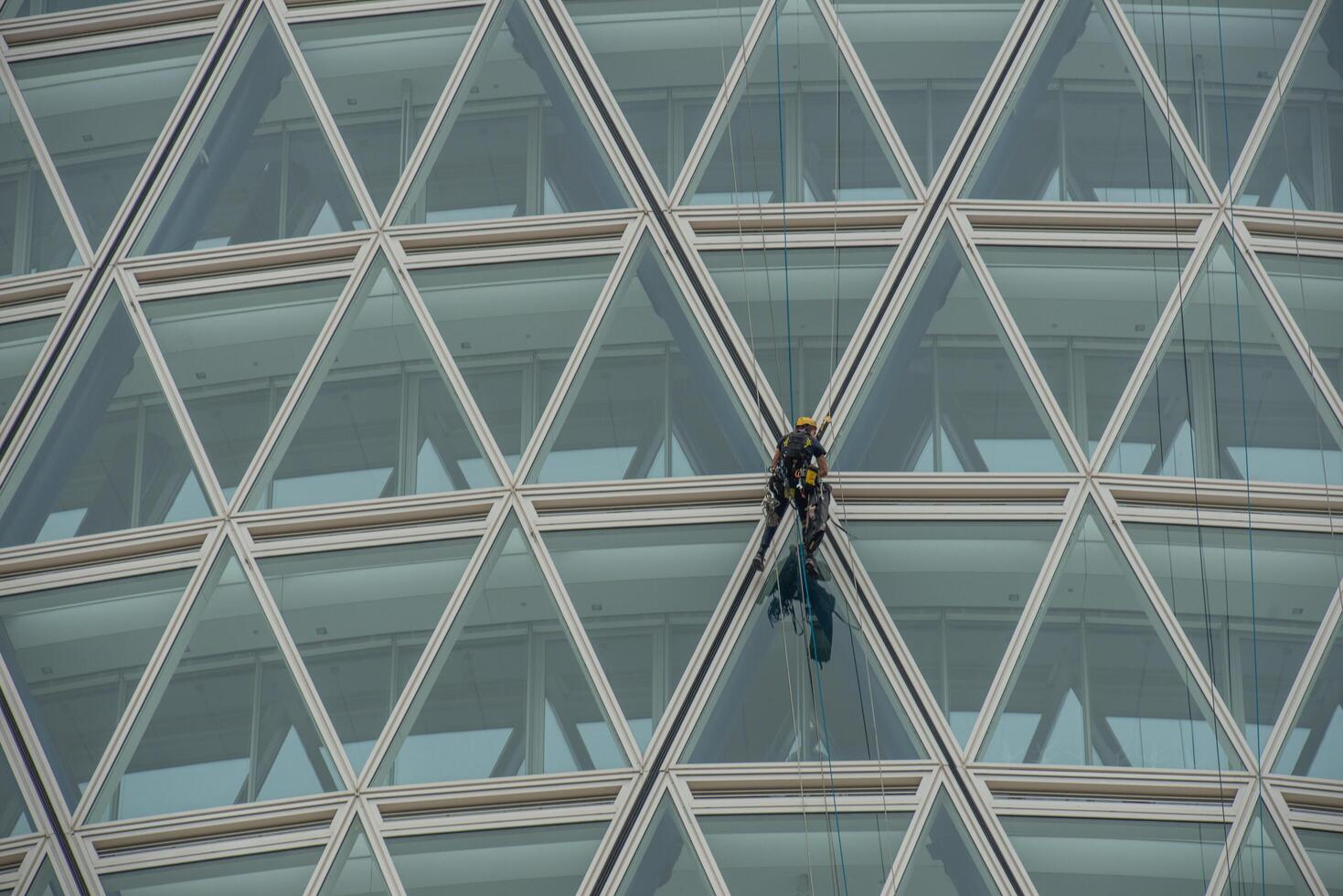 Italy 2024 A rope operator with a harness, lowering himself onto the facade of a building photo