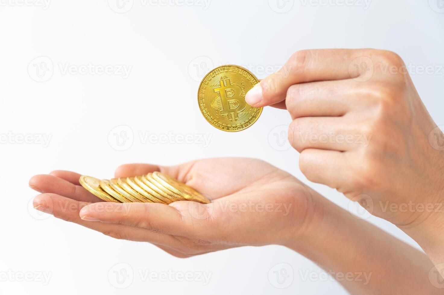 Someone hand holding some pieces of golden Bitcoin token isolated on white background. Bitcoin is one of the popular cryptocurrency, a virtual currency or a digital currency. photo
