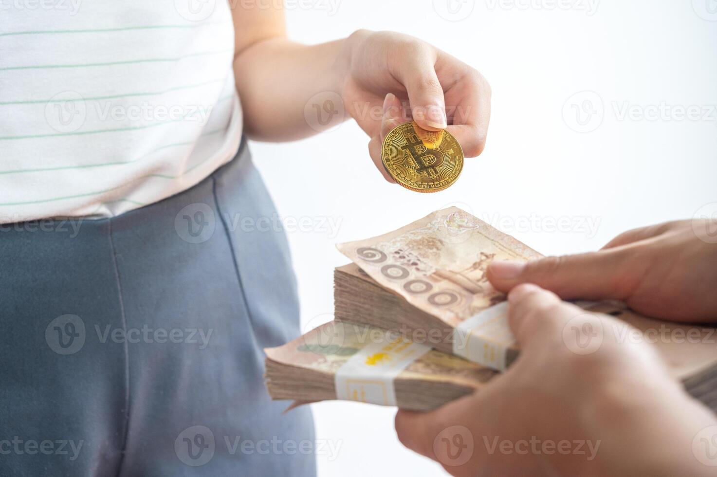 Cropped shot of people hands trading bitcoin token with Thai baht banknotes isolated on white background. Conceptual shot of financial and economic. photo